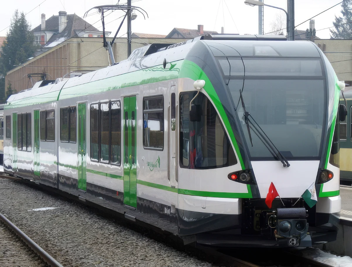 Grün-weißer Triebzug von Stadler am Bahnsteig